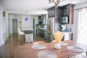 a kitchen and dining room with a wooden table at The Cityside Maple House in Falmouth