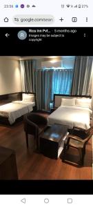 a picture of a hotel room with two beds and a table at Hotel Rica Inn in Namāi +1 photo