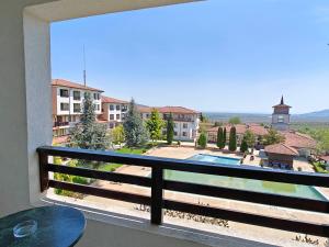 a balcony with a view of a pool and buildings at Daisy Studios Harmony Hills in Rogachevo