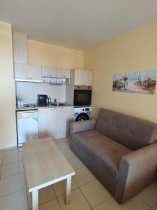 a living room with a couch and a kitchen at Daisy Studios Harmony Hills in Rogachevo