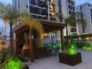 ein Gebäude mit einer Terrasse mit Tischen und Palmen in der Unterkunft Vista Park Sul in Brasilia