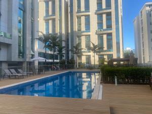 a swimming pool in front of a tall building at Vista Park Sul in Brasília