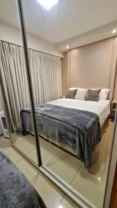 ein Schlafzimmer mit einem großen Bett und einem Spiegel in der Unterkunft Vista Park Sul in Brasilia