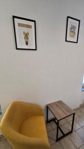 a living room with a yellow chair and a table at Charme de Loire in Blois