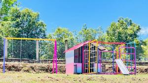 a playground with a colorful play structure in a field at Villanueva Casanare Country House in Villanueva