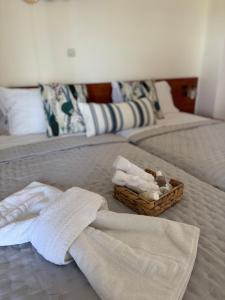 a bed with towels and a basket of towels at Χρυσή Αμμουδιά in Edipsos +32 photos