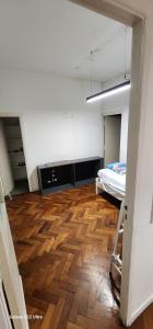 a large room with a bed and a wooden floor at Hospedaje reconquista in La Porteña