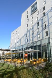un edificio con tavoli e sedie di fronte di Hôtel Lodge In Paris 13 a Parigi