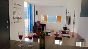 a room with a table with two glasses of wine at Apartahotel La Terraza - San Gil in San Gil +34 photos