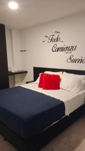 a bedroom with a bed with a red pillow at Apartahotel La Terraza - San Gil in San Gil