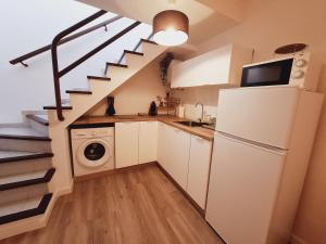 una cocina con nevera y lavadora en Home Wellness, en Playa del Inglés