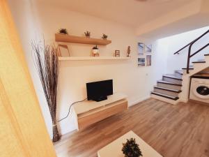 sala de estar con TV y escalera en Home Wellness, en Playa del Inglés