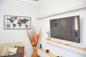 a living room with a large television on a wall at Kosmas Family House Apartment 2 in Kanálion
