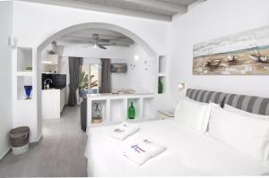 a bedroom with a white bed with two pillows on it at Skopelitis Village in Katapola