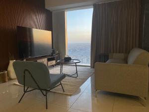 a living room with a television and a couch and chair at شقة برج رافال Rafal Tower in Riyadh