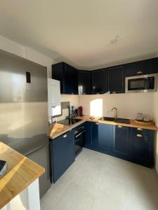 una cucina con armadi blu e piano di lavoro di 14th view Paris a Malakoff