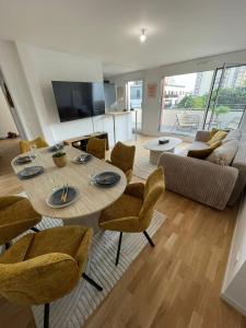 un soggiorno con tavolo, sedie e divano di 14th view Paris a Malakoff