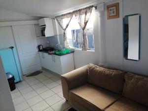 a living room with a couch and a kitchen at 37 Grant prix lodge in Cape Town