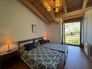 ein Schlafzimmer mit einem Bett und einem großen Fenster in der Unterkunft Casa Marisa en Cangas de Onís VV-2929-AS in Cangas de Onís