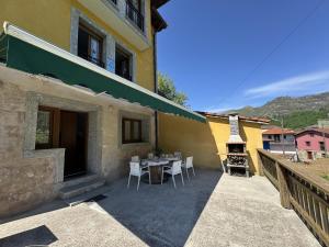 eine Terrasse mit einem Tisch und Stühlen neben einem Gebäude in der Unterkunft Casa Marisa en Cangas de Onís VV-2929-AS in Cangas de Onís