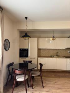 a kitchen with a table and chairs in a room at Enjoy 1 Apartmani in Podgorica