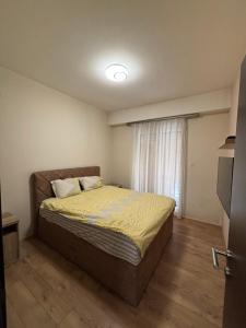 a bedroom with a bed in a room with a window at Enjoy 1 Apartmani in Podgorica