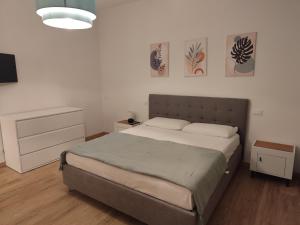 a bedroom with a bed and two paintings on the wall at Appartamento in centro by La Dolce Riva in Lugo