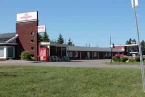 un edificio con una gasolinera con un cartel. en Kingsway Inn, en Thunder Bay