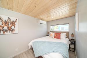 a small bedroom with a bed and a wooden ceiling at Dock Holiday, River Views at Roadrunner Resort in Parker