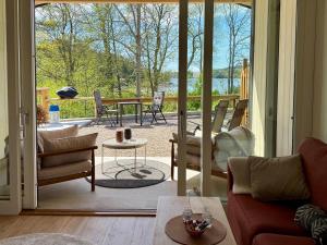 a living room with a door open to a patio at Hällesdalens Gård - semesterhus i Bohuslän in Svenshögen