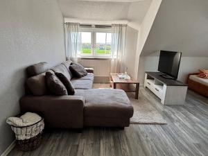 a living room with a couch and a television at Ruhige Ferienwohnung mit Waldblick in Horn-Bad Meinberg