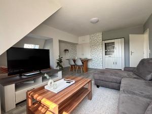 a living room with a couch and a flat screen tv at Ruhige Ferienwohnung mit Waldblick in Horn-Bad Meinberg