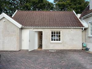 a white house with a garage and a roof at Studio in Tygelsjö in Tygelsjö