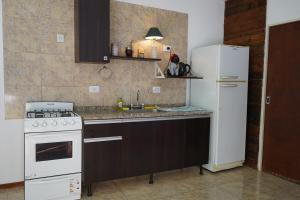 a kitchen with a white stove and a refrigerator at Departamento en Esperanza in Esperanza