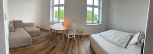 a bedroom with a bed and a table and a couch at Living 7 Apartments in Neufahrn in Niederbayern