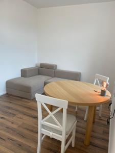 a living room with a table and a couch at Living 7 Apartments in Neufahrn in Niederbayern