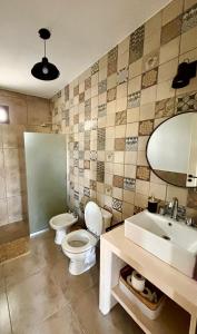 een badkamer met 2 toiletten, een wastafel en een spiegel bij La Corrida hospedaje in San Javier +8 foto's