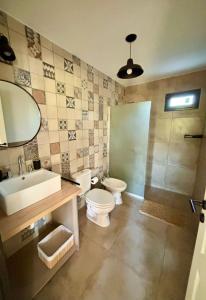 een badkamer met een toilet, een wastafel en een douche bij La Corrida hospedaje in San Javier