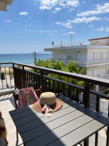 a hat sitting on a picnic table on a balcony at Sunset Apartments in Paralia Dionysiou +18 photos