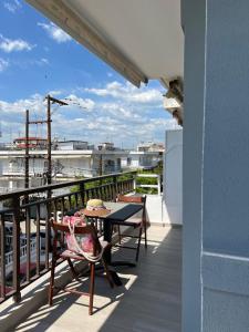 a patio with a table and chairs on a balcony at Sunset Apartments in Paralia Dionysiou