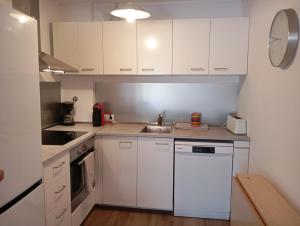 een kleine keuken met witte kasten en een spoelbak bij Apartamento en Llafranc Costa Brava in Llafranc