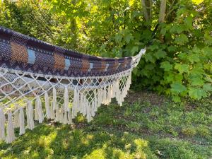 eine Hängematte, die von einem Baum im Hof hängt in der Unterkunft L'orée du bois in Saint-Valery-sur-Somme