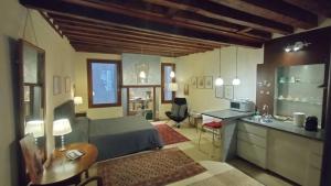 Una sala de estar con una cama y una cocina. en Suite Apartment San Marco 1825, en Venecia