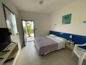 a bedroom with a bed and a tv and a window at Villaggio Turistico Europeo in Catania