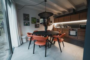 a kitchen with a black table and orange chairs at Quinta do Fradinho - Casa do Rio in Soajo