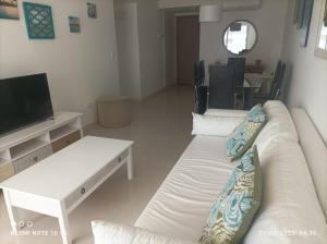 a living room with two white couches and a tv at Look Brava in Punta del Este