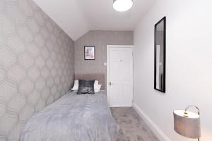 a bedroom with a bed and a wall at Modern 3 Bedroom Home in Central Rugby w Parking in Rugby