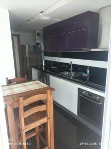 a kitchen with a stove and a sink and a wooden table at Look Brava in Punta del Este +25 photos