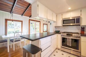 a kitchen with white cabinets and a black counter top at Hidden Lake House With Hot Tub & Views! in Corralitos