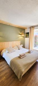 a large bedroom with a large bed with white sheets at Sous le tilleul in Gréoux-les-Bains